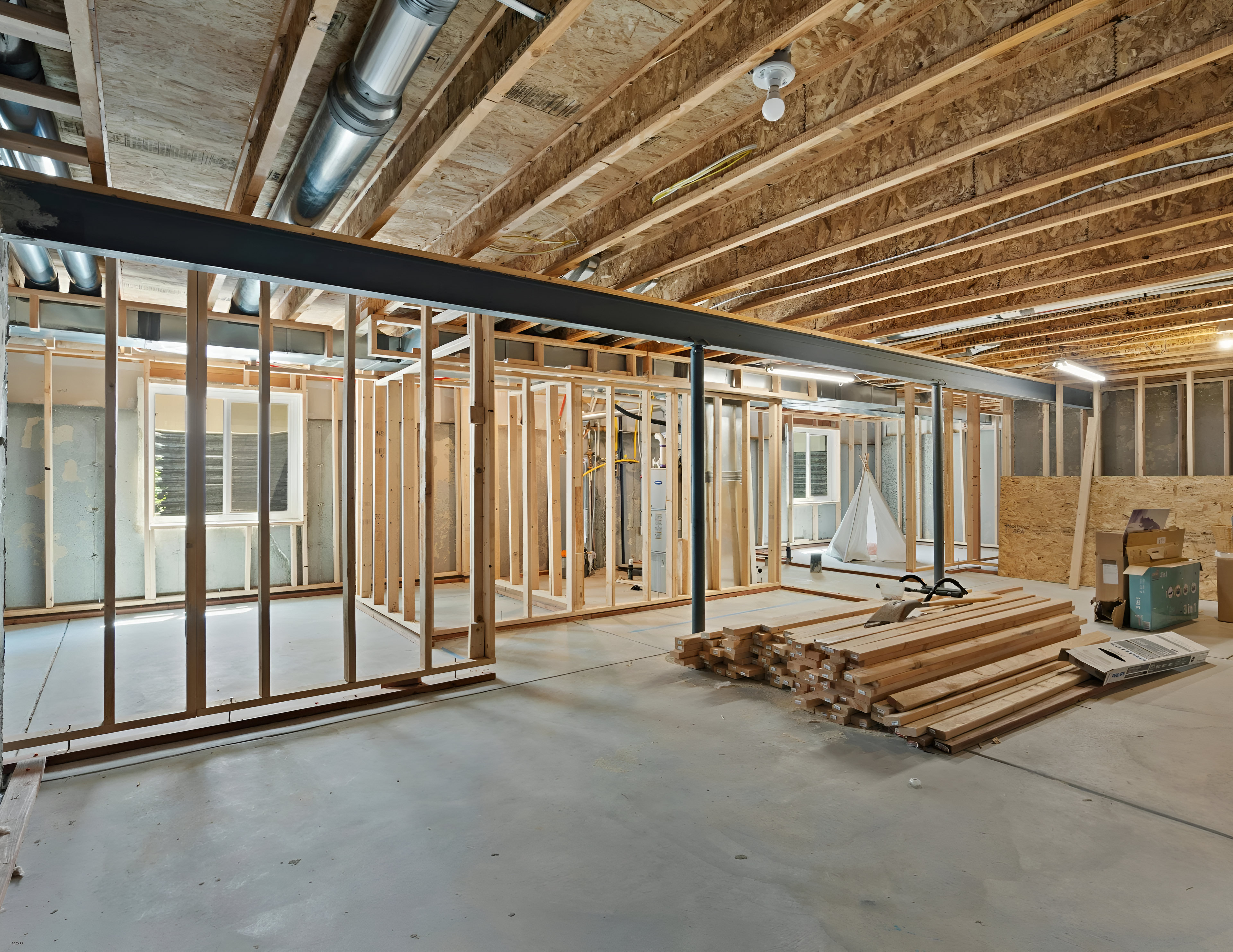 Open wood framing with plumbing and electrical visible before drywall